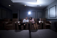 在家庭影院系统中观看电影的异族夫妇