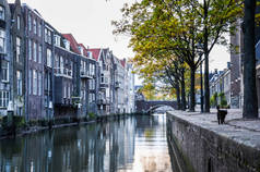 典雅的砖建筑和街道老镇的门面与房子在运河多云天在多德雷赫特荷兰。重要和历史性的港口城市, 毗邻河流。南荷兰.