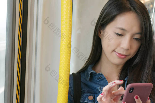 工作在移动电话的妇女, 流动办公室概念, 使用手机在<strong>火车车厢</strong>回复顾客消息