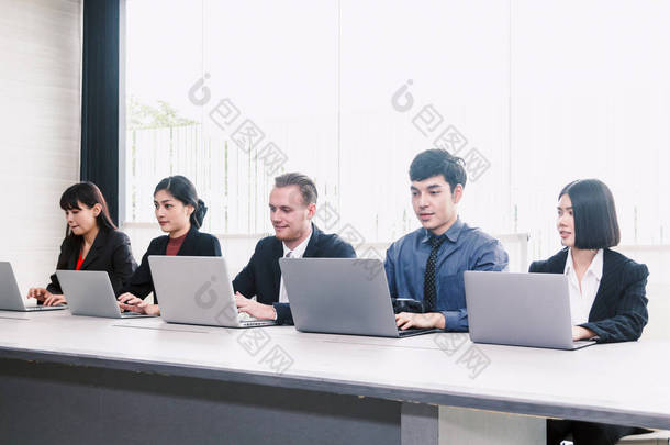 商人使用笔记本电脑, 并在<strong>会议室</strong>一起<strong>讨论</strong>。团队理念