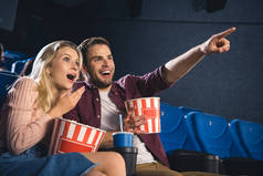 震惊夫妇与爆米花和苏打饮料一起看电影在电影院