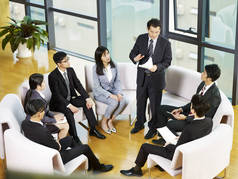 老板与亚洲商界人士在会议期间坐在一个圈子里讲话.