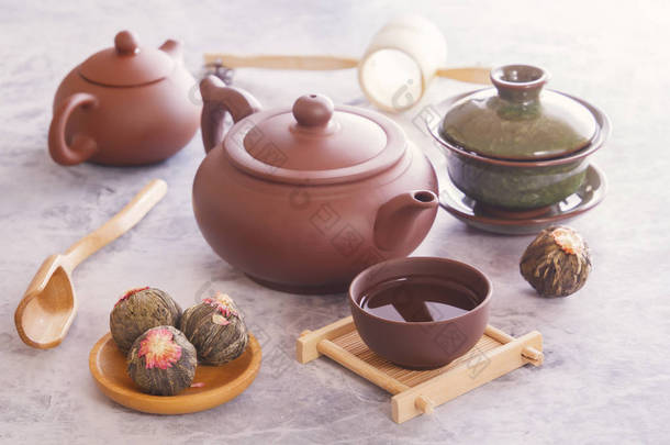绿茶芽, 棕色陶瓷茶壶, 为一个传统的亚洲<strong>茶道</strong>站在一个灰色的表准备一个杯子
