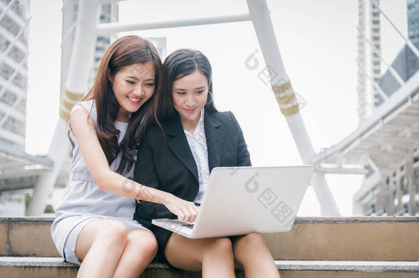 两位在笔记本电脑上工作的女商人带着快乐的搞笑情绪。业务办公室员工技术协作团队合作<strong>会议</strong>。<strong>营销</strong>与金融社区互动