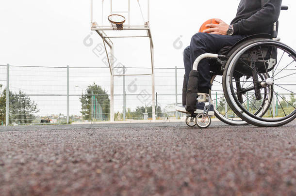 坐在轮椅上打篮球的年轻人.