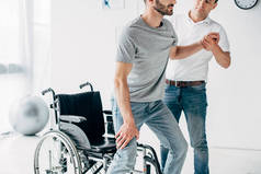 物理治疗师帮助残疾男子康复时的裁剪视图