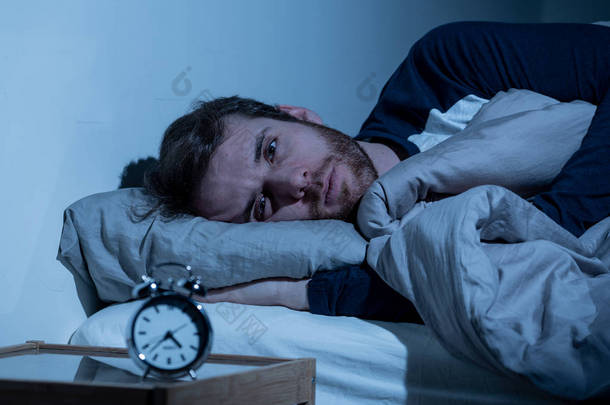<strong>失眠</strong>和绝望的年轻白种人男子晚上醒来不能睡觉,感到沮丧和担心看着时钟遭受<strong>失眠</strong>的压力和睡眠障碍的概念.