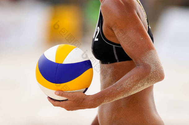 一名女子沙滩排球选手正准备开球
