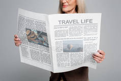 模糊的老年妇女拿着灰色的旅行报纸的景象
