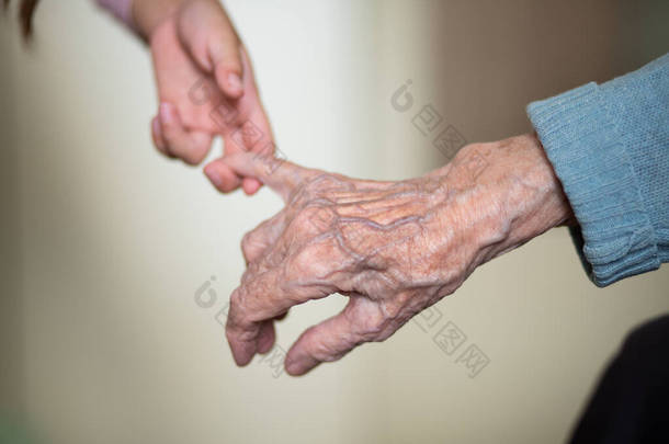 孩子的<strong>手</strong>在奶奶的<strong>手</strong>里，老女人的皮肤是棕色的，母亲的爱和<strong>呵护</strong>.