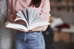 Many pages. Girl searching for some information in the library full of books.