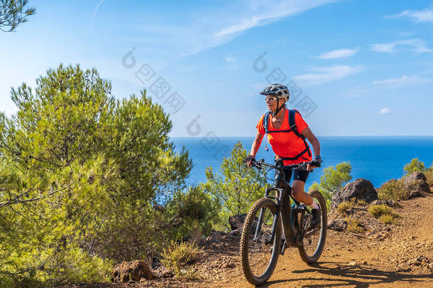 意大利<strong>托斯卡纳</strong>，<strong>托斯卡纳</strong>，一个漂亮的女人，骑着她的电动山地车，骑着她的电动山地车，走在意大利<strong>托斯卡纳</strong>，爱尔巴岛上的地中海沿岸