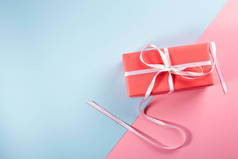 礼物在明亮的包装。粉色-蓝色背景