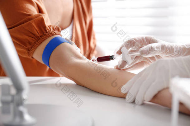 护士从诊所、特写镜头的病人身上抽取血液样本