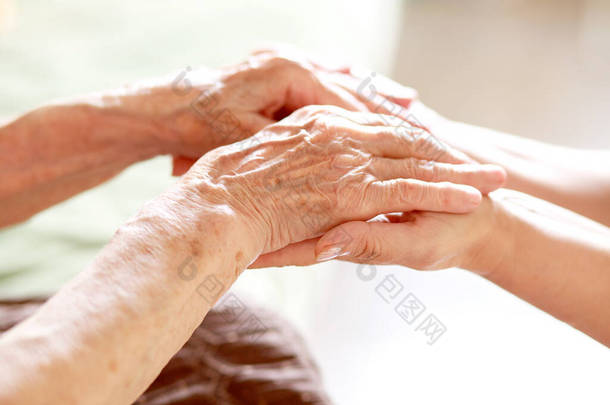孩子的手在奶奶的手里，老女人的皮肤是棕色的，母亲的爱和<strong>呵护</strong>.