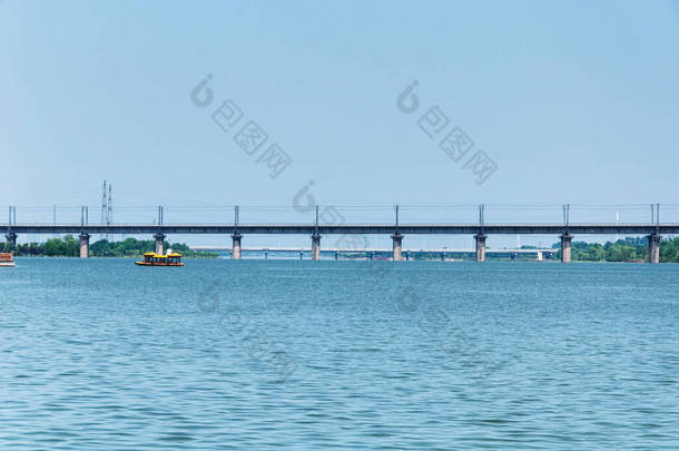 河南省洛阳市一座高速铁路桥附近的一艘旅游船穿过宜江.