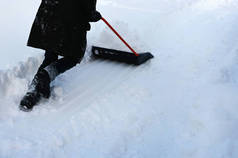 在郊区，人们用铲子铲雪。暴风雪过后，冬季清理了道路。冬季时间