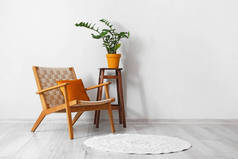 舒适的扶手椅和凳子，室内轻墙附近有室内盆栽