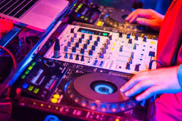 DJ是转盘式转盘搅拌器夜间派对酒吧运动模糊了抽象的背景.