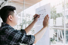 室内设计人员或建筑师审查设计图，并将铅笔图纸放在总公司的桌子上.