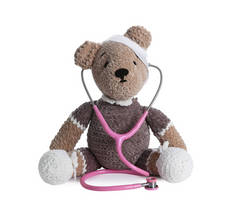 可爱的玩具熊与绷带和听诊器隔离在白色。儿童医院
