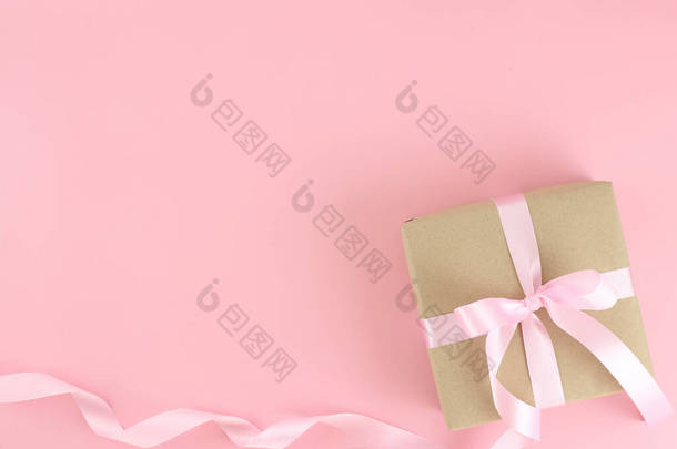 褐色纸制礼品盒，<strong>粉</strong>红缎子卷丝带蝴蝶结在<strong>粉</strong>红的背景上。平铺<strong>母亲节</strong>、父亲节、情人节、带有复制空间的生日观念.