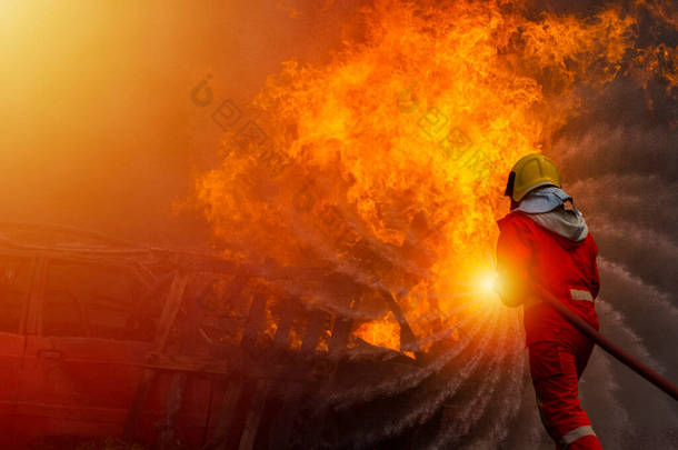 一名身穿西装、头戴头盔的消防员正在扑灭起火的大火，请回答.