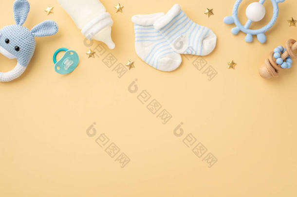 婴儿用品概念。针织兔子玩具蓝色聚醚奶瓶小袜子奶嘴和金色<strong>星辰</strong>在孤立的白色米色<strong>背景</strong>与空旷的空间的俯瞰照片
