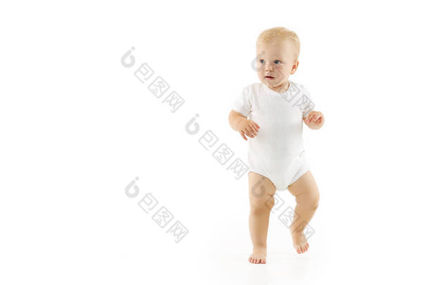 可爱的婴儿学会了在白色孤立的背景下走路。穿着白衣快乐微笑的孩子<strong>迈出</strong>了自信的<strong>第一步</strong>