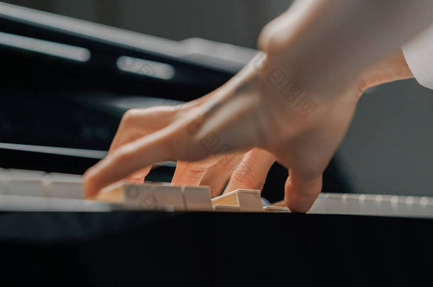 优秀的女钢琴家用纤细的手指弹钢琴，弹奏乐器