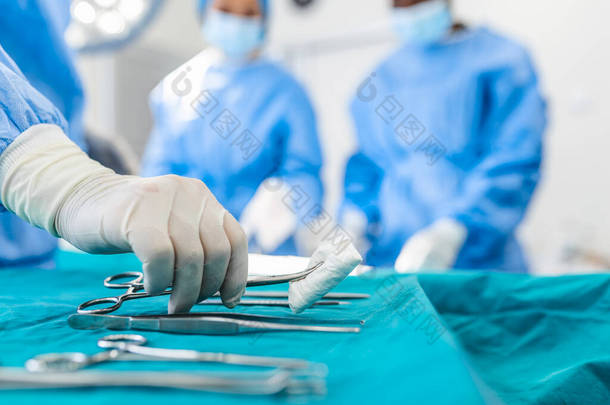 护士手<strong>外科</strong>医生在背景作业在<strong>外科</strong>手术室病人组采取<strong>外科</strong>手术器械。钢的医疗仪器随时可以使用。<strong>外科</strong>手术和紧急的概念