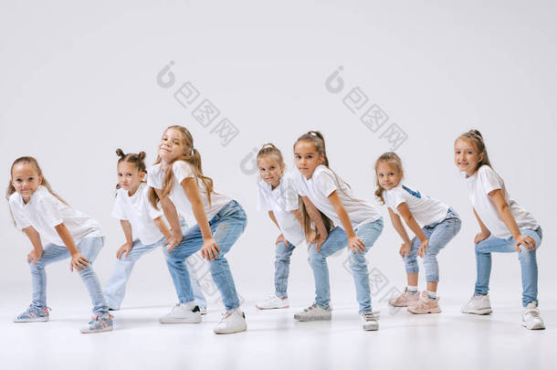 Joy, fun and happiness. Portrait of happy, active little girls, sportive kids in casual clothes danc