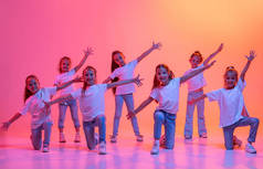 Hip-hop dance, street style. Group of children, school age girls in casual style clothes dancing in 
