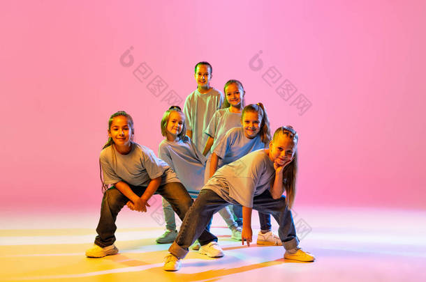 Joy, fun and happiness. Portrait of cheerful, active little girls, <strong>happy</strong> kids dancing isolated on or