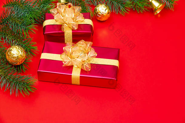 圣诞节<strong>背景</strong>概念。圣诞<strong>礼品盒</strong>金球的顶部视图，金球上有云杉枝和红色<strong>背景</strong>的铃铛.