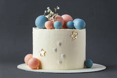 婴儿淋浴派对蛋糕，白色奶油奶酪泡沫装饰蓝色和粉色巧克力球。猜猜即将出生的孩子的性别他或她的蛋糕。透露未出生婴儿的性别.