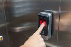 电梯里使用手指指纹扫描仪的女人办公室和公寓安保系统概念