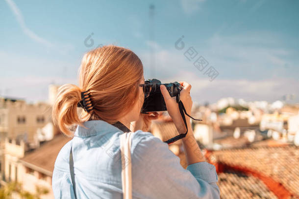 在西班牙瓦伦西亚旧城，积极的<strong>女性游客</strong>在日落时用相机拍照。背景色