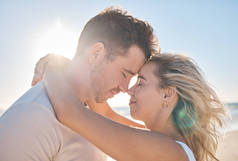 在加拿大多伦多度蜜月时，情侣们拥抱在海滩上，爱抚着他们的丈夫和妻子的额头。在浪漫的日子里，蓝天的光芒、自由、和平与婚姻的结合.