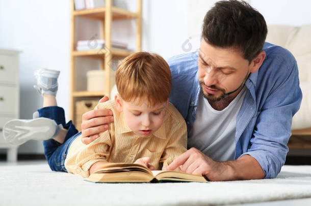 <strong>父亲和儿子在家里</strong>客厅的地板上看书