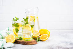 柠檬水在白桌边的两杯玻璃杯里.夏天的饮料，传统的点心鸡尾酒.