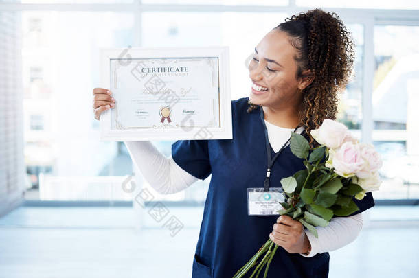 证书、鲜花和一名黑人妇女毕业于医院，为自己的成就感到自豪。一个快乐的年轻女<strong>护士</strong>独自<strong>站</strong>在诊所，她的笑容、毕业和资质.