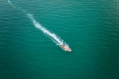 白色游艇在波涛汹涌的海面上漂浮的空中景象。在海上航行的摩托艇.