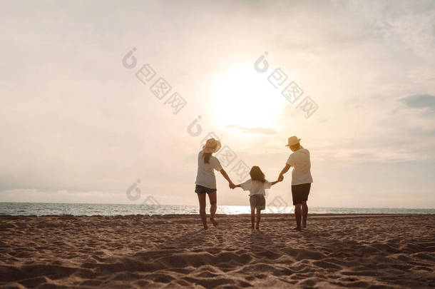 快乐的亚洲家庭在海滨享受着由父亲、母亲和女儿组成的海滩，暑假在海滩上玩得很开心。有度假时间的快乐家庭生活方式概念.