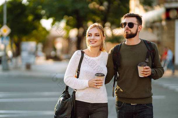 年轻夫妇一边聊天，一边喝咖啡和打电话，一边在早上的城市里散步。Relaxation, youth, <strong>love</strong>, lifestyle, selfie, blog.