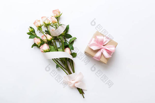 设计理念与粉红色玫瑰花和礼品盒的彩色桌子背景图。节日快乐,母亲节快乐,生日快乐.浪漫的平铺构图.