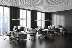 现代开放空间办公室的角落，有灰色和混凝土墙、木制地板、一排有灰色椅子和高窗的电脑桌。3d渲染