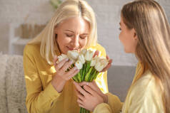 年轻女人在家里用郁金香和母亲打招呼，特写镜头