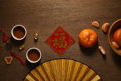 扇子, 新鲜成熟的橘子, 金色的象形文字, 在木表面的茶杯和硬币