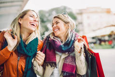快乐的女性朋友购物。两位美丽的年轻女性在城市购物